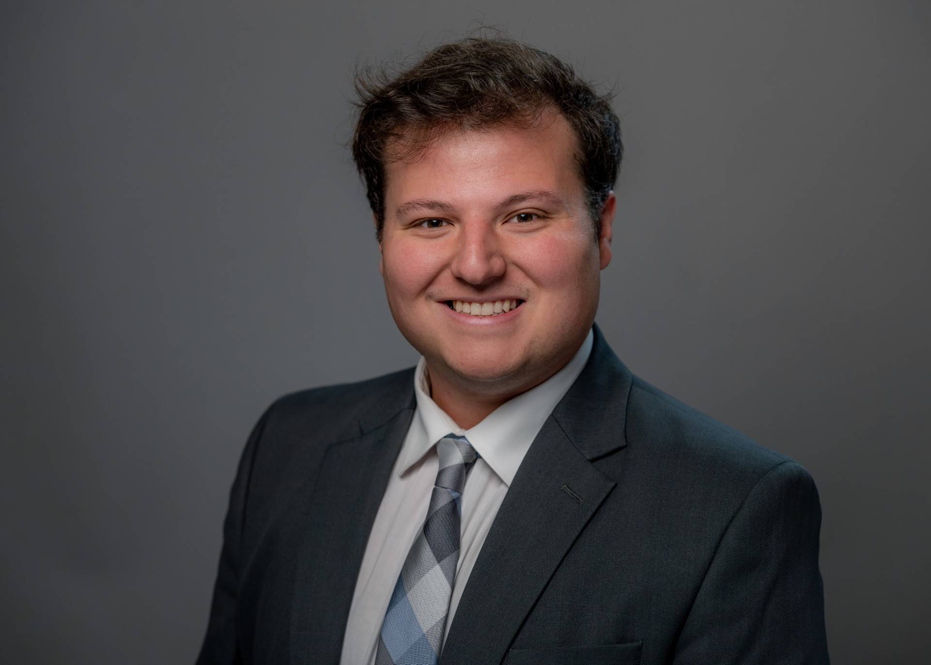 Brian Roberts smiling wearing a suit.